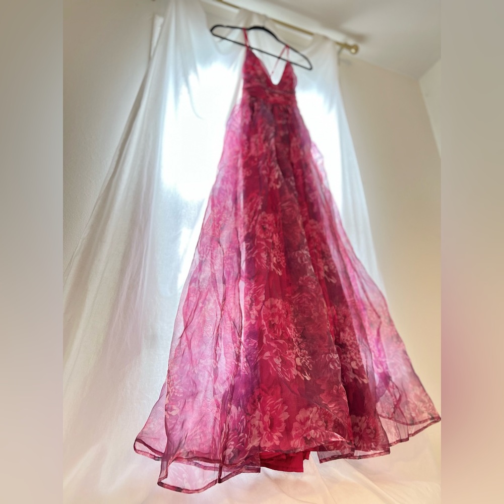 Red floral dress. Adjustable straps, hugs around the waist and flows down.